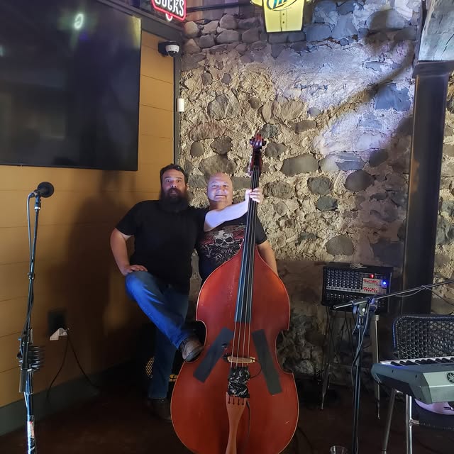 Jim and Rob posing with the upright bass at a venue